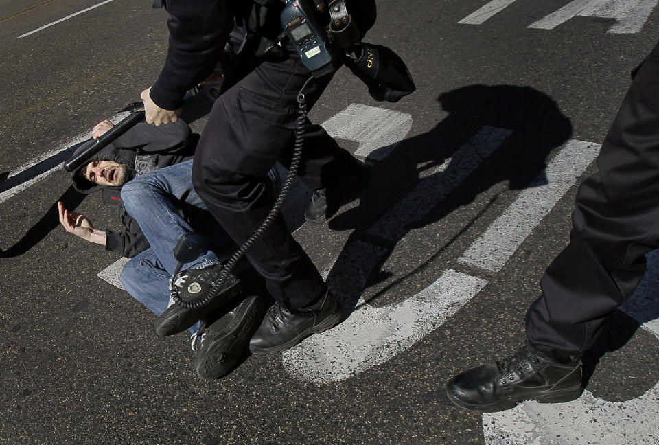 <p>A protester is grabbed by police in Madrid, March 29, 2012, during a general strike. Flag-waving Spanish workers angered by reforms they see as flagrantly pro-business blocked traffic, formed boisterous picket lines outside wholesale markets and bus garages, and kept some TV programming off the air. (AP Photo/Andres Kudacki) </p>