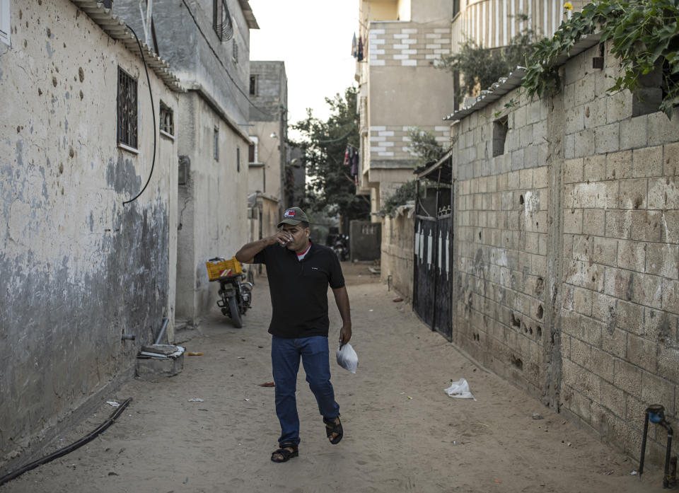 Palestinian Ibrahim Slaieh drinks coffee in the morning before crossing into Israel to work in Beersheba, in Khan Younis southern Gaza Strip, Sunday, Aug 21, 2022. Since 2021, Israel has issued over 15,000 permits allowing some Palestinians from the Gaza Strip to work in Israel. Their wages are far higher than those available inside Gaza. With Gaza's economy in freefall, these permits are highly coveted and have given an important economic boost to thousands of families. But even Israel acknowledges the system is a powerful tool to preserve calm or — as critics say — control. (AP Photo/Fatima Shbair)