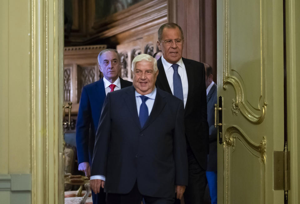 Syrian Foreign Minister Walid Muallem, center, and Russian Foreign Minister Sergey Lavrov, right, enter a hall for their joint news conference followed their talks in Moscow, Russia, Thursday, Aug. 30, 2018. Muallem's Moscow visit comes as Moscow and Damascus are increasingly worried about a possible airstrike on government positions in Syria. (AP Photo/Alexander Zemlianichenko)