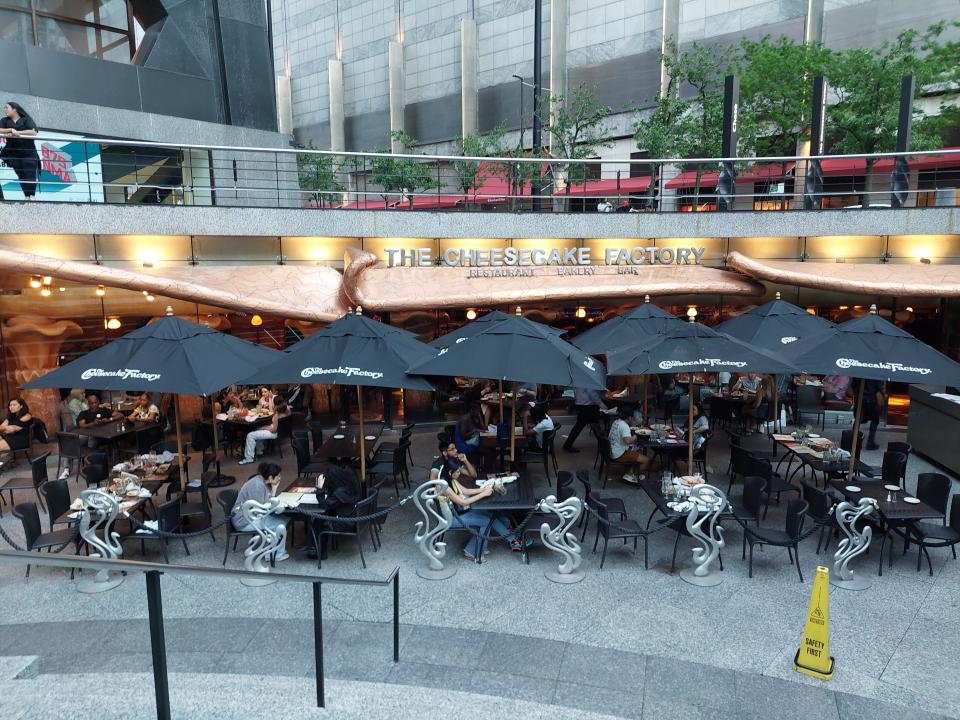 The exterior of the Cheesecake Factory in Chicago on the Magnificent Mile. The photo shows its outdoor seating