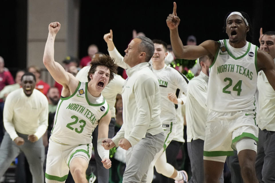 North Texas head coach Grant McCasland, center, celebrates with players after a win over Wisconsin in an NCAA college basketball game in the semifinals of the NIT, Tuesday, March 28, 2023, in Las Vegas. (AP Photo/John Locher)