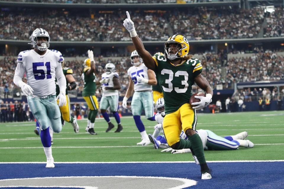 Aaron Jones #33 of the Green Bay Packers celebrates after scoring on an 18-yard run against the Dallas Cowboys in the first quarter of their game at AT&T Stadium on October 06, 2019 in Arlington, Texas.