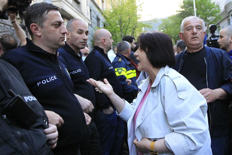 A woman speaks to police officers as protesters gather outside the parliament building in Tbilisi, Georgia, on Tuesday, April 16, 2024, to protest against the "the Russian law" similar to a law that Russia uses to stigmatize independent news media and organizations seen as being at odds with the Kremlin. (AP Photo/Shakh Aivazov)