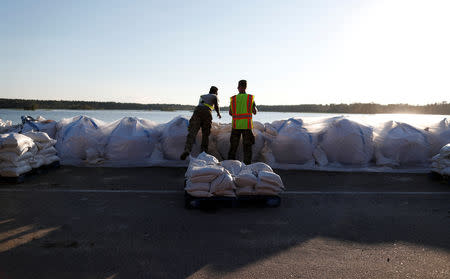 Members of the National Guard work on a long sand bag flood barrier being built by the South Carolina Department of Transportation on U.S. 501 to lesson damage to roads anticipated from floods caused by Hurricane Florence, now downgraded to a tropical depression, in Conway, South Carolina, U.S. September 19, 2018. REUTERS/Randall Hill