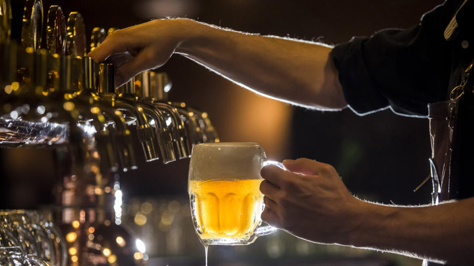 A getty stock image of a person pouring a beer from a pub