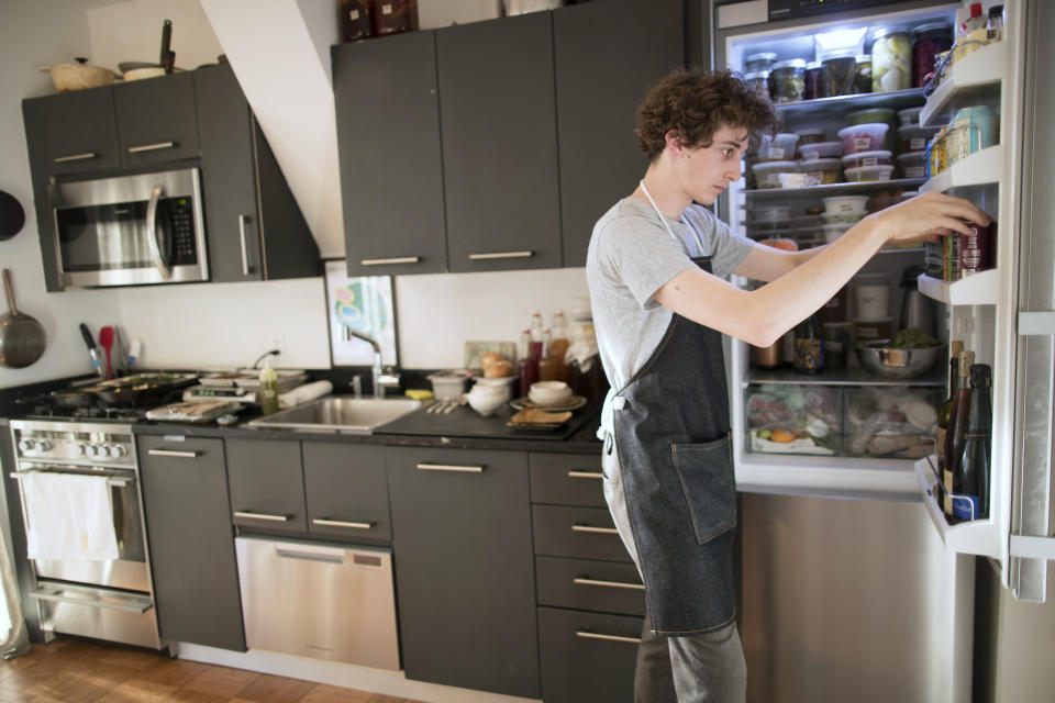 In this May 17, 2019, photo Jonah Reider prepares a Pith dinner at his New York apartment. “Don’t call me a chef,” he says with a grin, explaining, “I think of myself as a good home cook. The food is upscale, but very simple.” (AP Photo/Mary Altaffer)