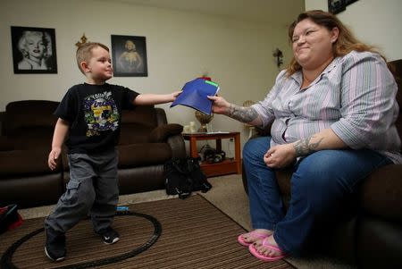 Joshua Sekerak hands his mom Jennifer his school behavior report at their home in Leetonia, Ohio, United States on May 21, 2016. REUTERS/Aaron Josefczyk