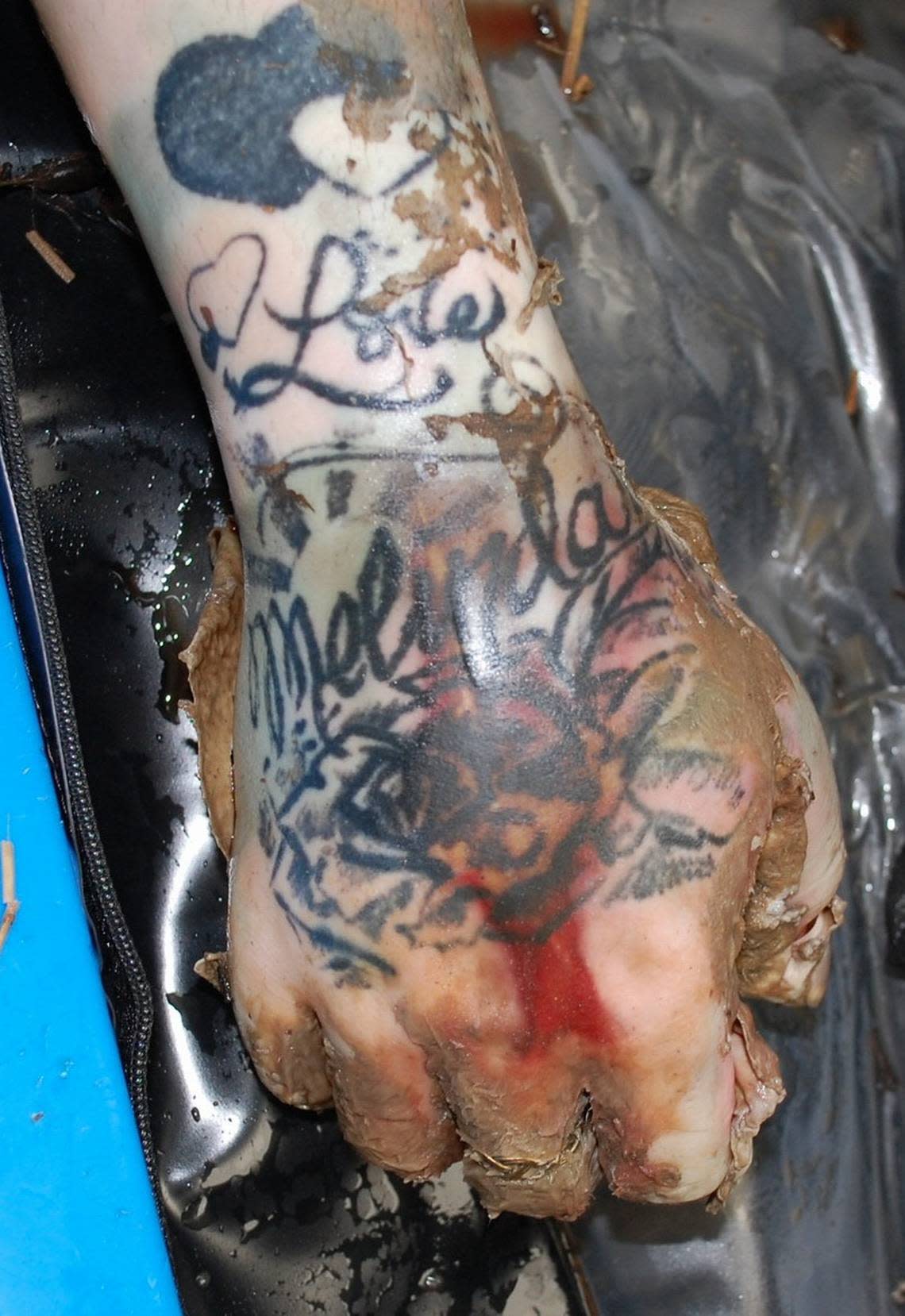 The person’s right hand tattooed with “love Melinda.”