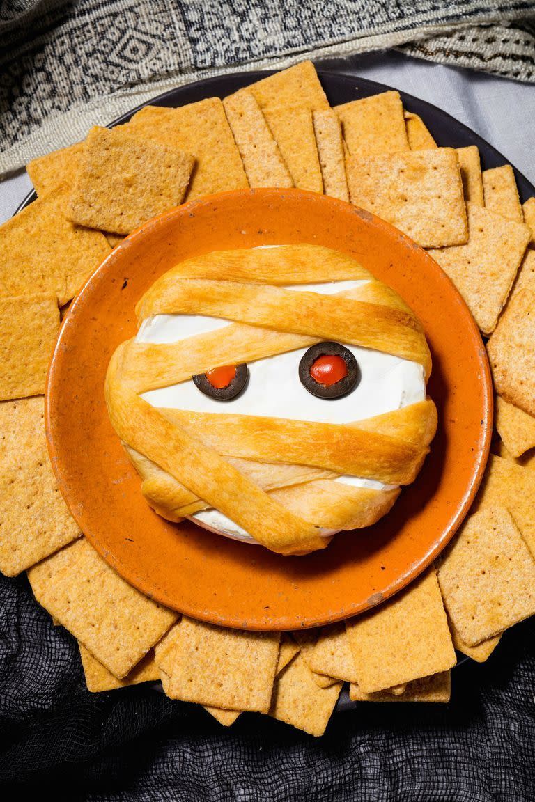 <p>Thanks to puff pastry, your basic baked brie becomes a totally spooky Halloween appetiser.</p><p>Get the <a href="https://www.delish.com/uk/cooking/recipes/a29221680/mummy-brie-recipe/" rel="nofollow noopener" target="_blank" data-ylk="slk:Mummy Brie;elm:context_link;itc:0;sec:content-canvas" class="link ">Mummy Brie</a> recipe.</p>