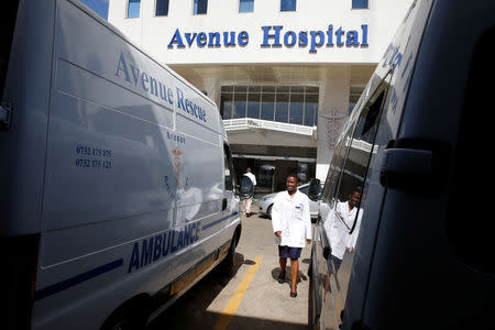 A health worker walks between parked ambulances at the Avenue hospital in Nairobi, Kenya February 1, 2019. Picture taken February 1, 2019. REUTERS/Baz Ratner