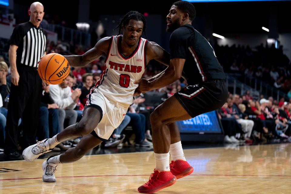 Detroit Mercy Titans guard Antoine Davis (0) drives on Cincinnati Bearcats guard David DeJulius (5) in the second half of the NCAA men’s basketball game at Fifth Third Arena in Cincinnati on Wednesday, Dec. 21, 2022. Cincinnati Bearcats defeated Detroit Mercy Titans 72-54. 