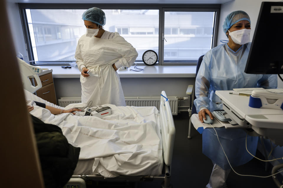 Nurses care for a COVID-19 patient in the infectious disease ward of the Strasbourg University Hospital, eastern France, Thursday Jan. 13, 2022. The omicron variant is exposing weaknesses at the heart of Europe's public health system. In France and Britain, a sharp rise in coronavirus hospitalizations coupled with staff falling sick has led to a shortage of beds. (AP Photo/Jean-Francois Badias)