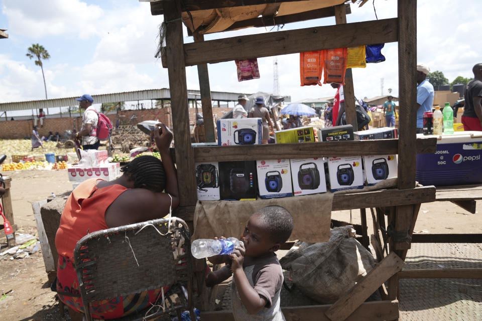 A woman sells small radio sets at a busy local marketplace stall in Harare, Thursday, Feb. 2, 2023. In many Western countries, conventional radio has been overtaken by streaming, podcasts and on-demand content accessed via smartphones and computers. But in Zimbabwe and much of Africa, traditional radio sets and broadcasts are widely used, highlighting the digital divide between rich countries and those where populations struggle to have reliable internet. (AP Photo/Tsvangirayi Mukwazhi)