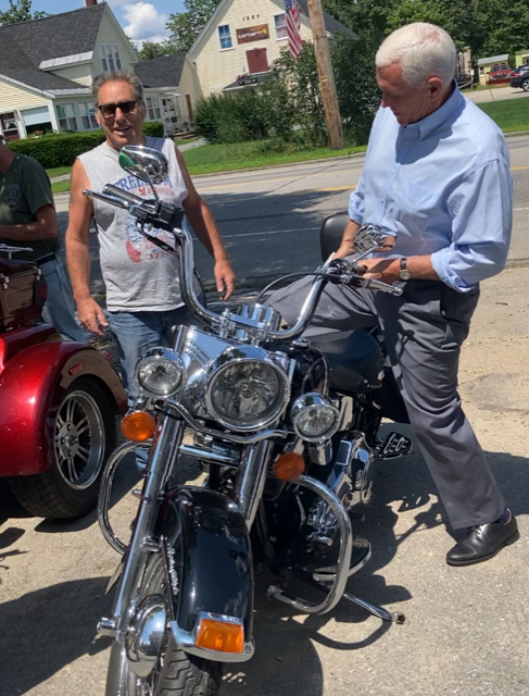 ormer Vice President Mike Pence checks out the motorcycle of Eddie Rossetti, 62, a mechanic from Atkinson, N.H. Pence, who is running for the 2024 GOP nomination for president, met Rossetti outside Calef's Country Store in Barrington, N.H.
