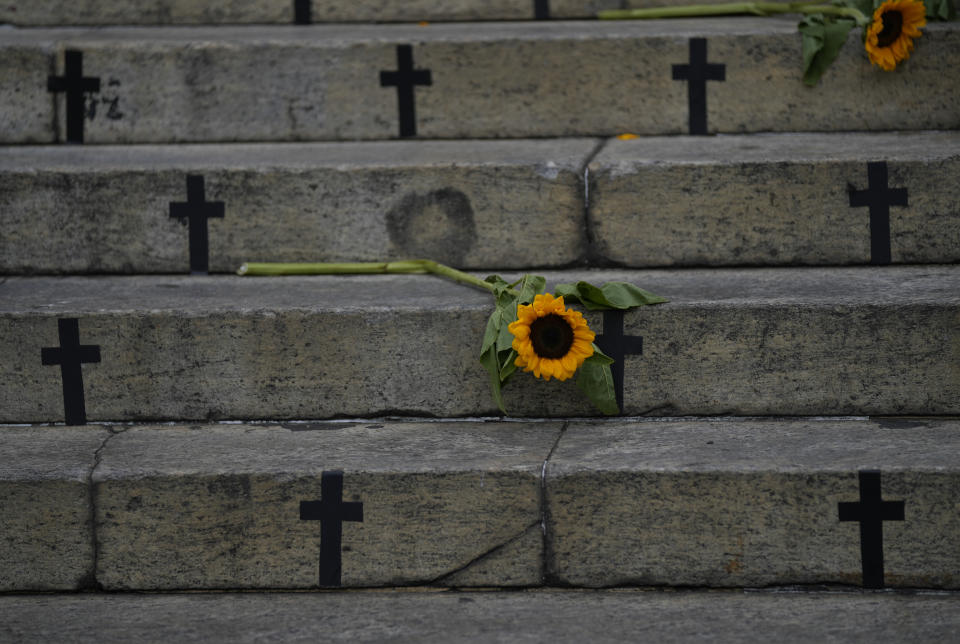 Sunflowers and crosses cover the City Council steps during a protest against femicide on International Women's Day in Rio de Janeiro, Brazil, Friday, March 8, 2024. (AP Photo/Silvia Izquierdo)