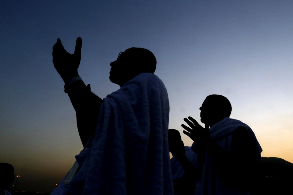 Muslim pilgrims pray on a rocky hill known as Mountain of Mercy, on the Plain of Arafat, during the annual hajj pilgrimage ahead of sunrise near the holy city of Mecca, Saudi Arabia, Saturday, Aug. 10, 2019. More than 2 million pilgrims were gathered to perform initial rites of the hajj, an Islamic pilgrimage that takes the faithful along a path traversed by the Prophet Muhammad some 1,400 years ago. (AP Photo/Amr Nabil)