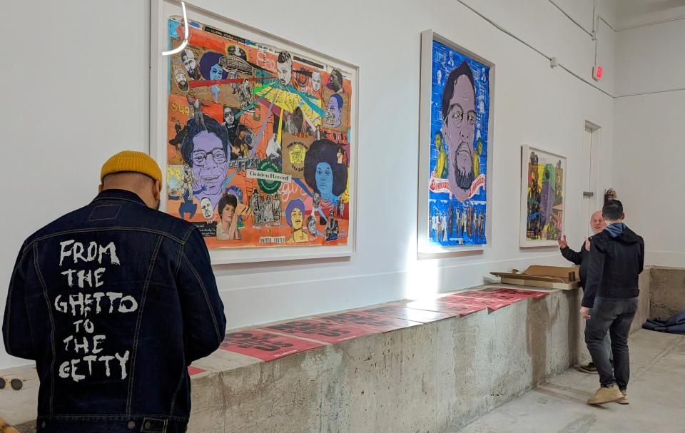 Robert Hodge takes a break to check his phone while setting up "No Kings But Us." The exhibition's power comes from the fact that "it's not just a white person saying this stuff, (it's) not just a Black person saying this. It's both of us together saying this," Kerr said.