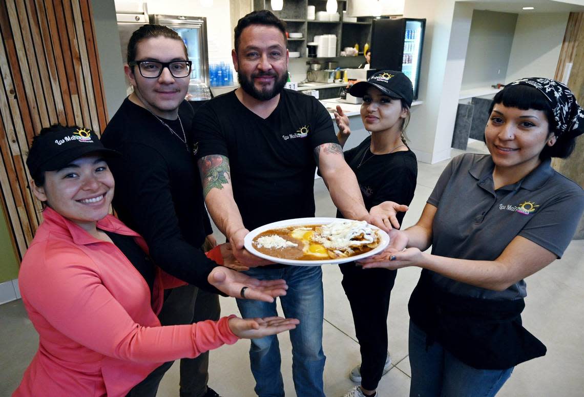 Allen Juarez, co-owner of Las Manañitas, center, shown with staff and a plate of their famous chilaquiles at their second location, this one in the Bitwise State Center Warehouse on R Street Tuesday, Jan. 10, 2023 in downtown Fresno.