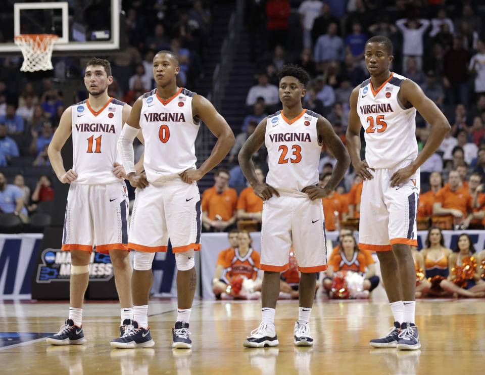 FILE - Virginia's Ty Jerome, Devon Hall, Nigel Johnson and Mamadi Diakite, from left, watch as a UMBC player shoots free throws during the second half of a first-round game in the NCAA men's college basketball tournament in Charlotte, N.C., March 16, 2018. Five years ago Thursday a tiny school few had ever heard of — and virtually no one gave an ounce of a chance to win — pulled off the biggest upset in tournament history as University of Maryland-Baltimore County knocked off the tournament’s top overall seed, elevating March Madness to a whole new level. (AP Photo/Gerry Broome, File)