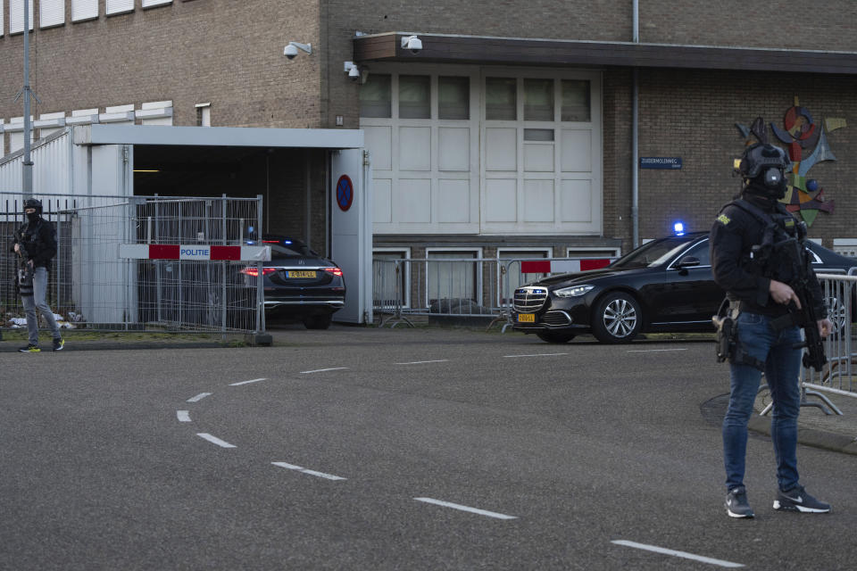 Masked and armed Dutch police guard a transport of some of the suspects who arrived at the high security court building where the trial opened in Amsterdam, Netherlands, Tuesday, Jan. 23, 2024, for suspects in the slaying of campaigning Dutch journalist Peter R. De Vries. A long-delayed trial opened Tuesday of nine men accused of involvement in the fatal shooting on a downtown Amsterdam street of Dutch investigative reporter de Vries. (AP Photo/Peter Dejong)