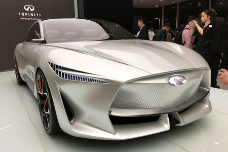 A woman takes picture of Infiniti's Q Inspiration concept car at an event in Beijing, China April 23, 2018. REUTERS/Joe White