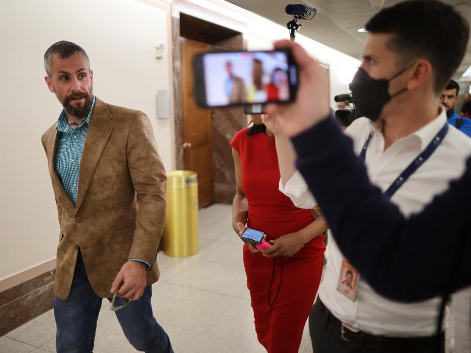 DC Metropolitan Police Officer Michael Fanone (left) is followed by reporters as he heads to a meeting with Sen Susan Collins. (Getty Images)
