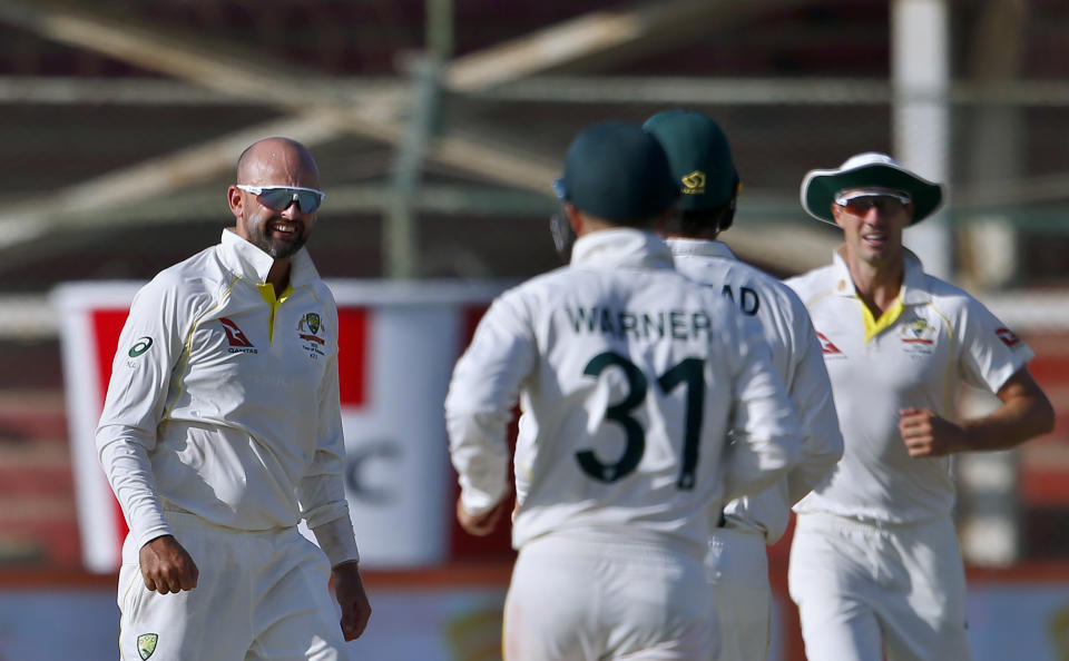 Australia's Nathan Lyon, left, and teammates celebrate after the dismissal of Pakistan's Babar Azam on the fifth day of the second test match between Pakistan and Australia at the National Stadium in Karachi Pakistan, Wednesday, March 16, 2022. (AP Photo/Anjum Naveed)