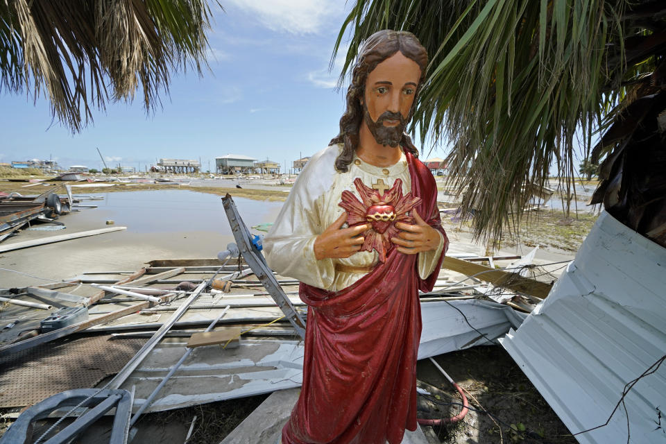 A statue of Jesus that had fallen during Hurricane Laura was uprighted by unknown persons, amid devastation in Holly Beach, La., in the aftermath of the hurricane, Saturday, Aug. 29, 2020. (AP Photo/Gerald Herbert)