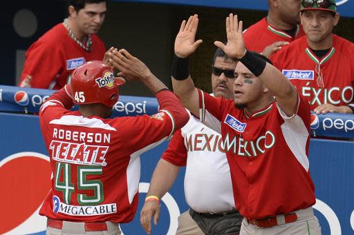 Chris Roberson, de los Naranjeros de Hermosillo de México (I), celebra su victoria contra los Indios de Mayagüez de Puerto Rico, en su primer enfrentamiento del 2 de febrero de 2014 en Isla Margarita (Venezuela) (AFP | LEO RAMIREZ)