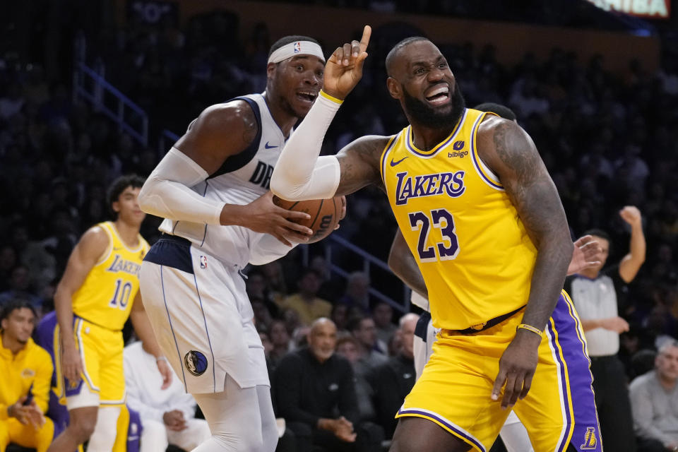 Los Angeles Lakers forward LeBron James (23) argues for a foul, next to Dallas Mavericks forward Richaun Holmes during the first half of an NBA basketball game Wednesday, Nov. 22, 2023, in Los Angeles. (AP Photo/Marcio Jose Sanchez)