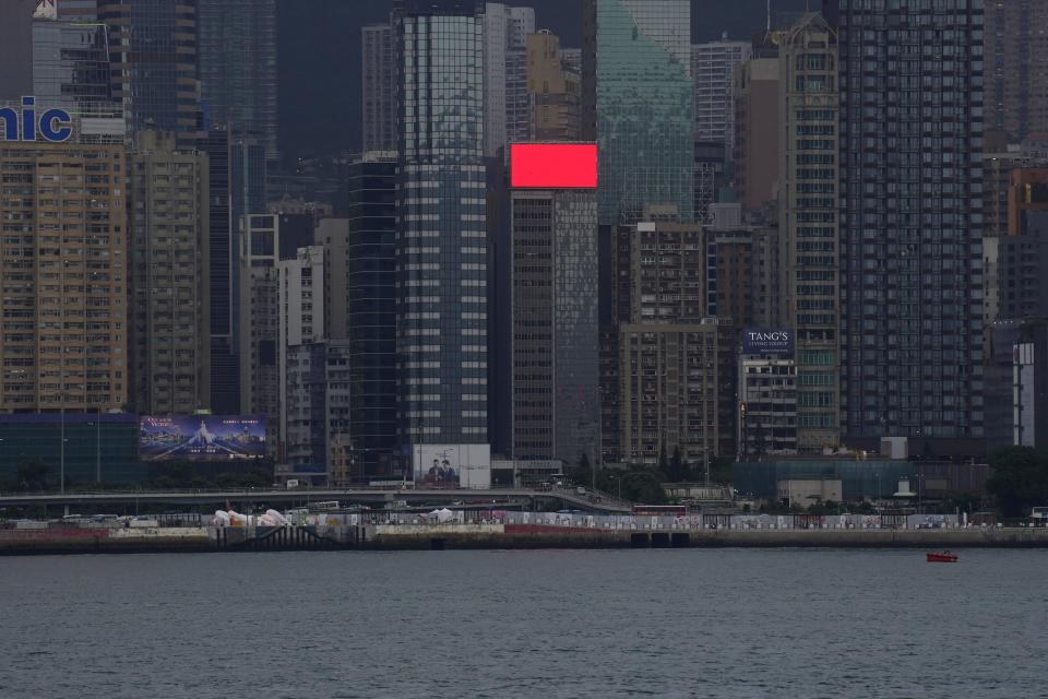 An electronic red monitor is seen at some highrise buildings in Hong Kong Tuesday, June 29, 2021. Hong Kong is still China’s wealthiest, most capitalist city. Its vistas of skyscraper and sea framed by dragon-backed emerald peaks are as stunning as ever. But a year after Beijing imposed a harsh national security law on the former British colony, the civil liberties that raised hopes for more democracy among many of its 7 million people are fading. (AP Photo/Vincent Yu)