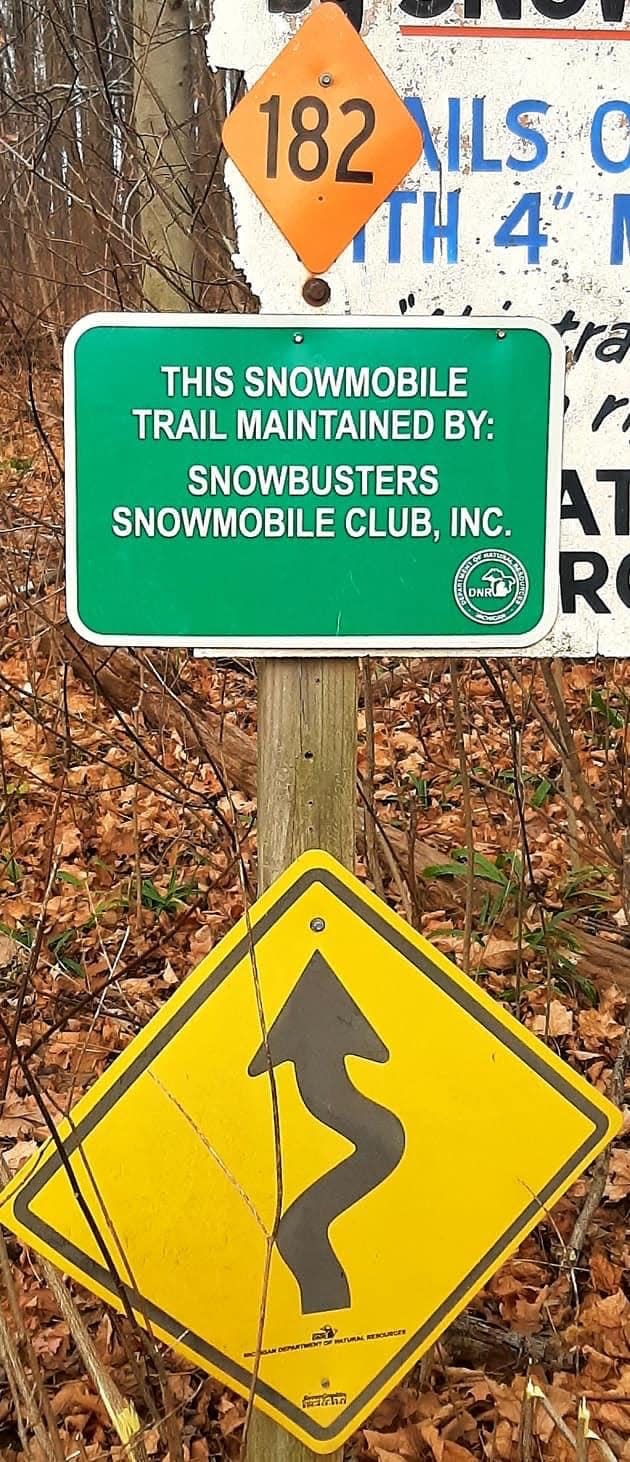 Signs mark Trail 182 in southwest Michigan and show that it's maintained by the Snowbusters Snowmobile Club.