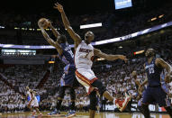 Charlotte Bobcats' Kemba Walker (15) grabs a rebound over Miami Heat's Chris Bosh (1)during the first half in Game 1 of an opening-round NBA basketball playoff series, Sunday, April 20, 2014, in Miami. (AP Photo/Lynne Sladky)