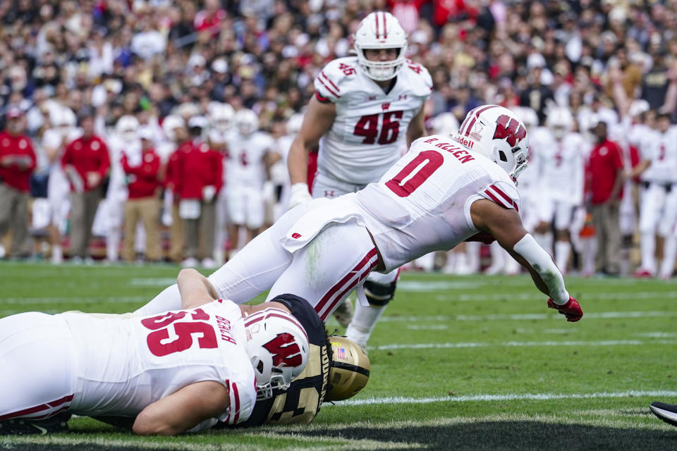 Wisconsin running back Braelon Allen (0) dives in for a touchdown over Purdue linebacker Kieren Douglas (43) during the first half of an NCAA college football game in West Lafayette, Ind., Saturday, Oct. 23, 2021. (AP Photo/Michael Conroy)