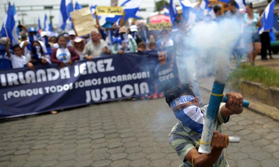 An anti-government demonstrator fires a home-made mortar as he takes part in a march demanding the resignation of Nicaraguan President Daniel Ortega and his wife