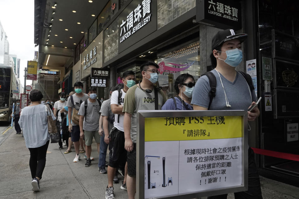 Gaming enthusiasts queue up for the pre-order sales of the newly unveiled Japanese brand video game console, Sony's PlayStation 5 (PS5), outside a retailer in Hong Kong, Friday, Sept. 18, 2020. Pre-orders of PlayStation 5 started on Sept. 17 and will be filled on Nov. 19. (AP Photo/Kin Cheung)