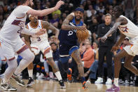 Minnesota Timberwolves guard Nickeil Alexander-Walker drives between Phoenix Suns center Jusuf Nurkic (20), guard Bradley Beal (3) and center Bol Bol during the second half of an NBA basketball game Friday, April 5, 2024, in Phoenix. (AP Photo/Rick Scuteri)