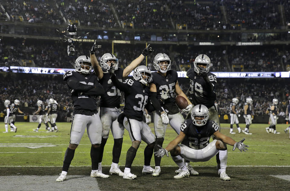 Oakland Raiders defensive back Erik Harris, top second from right, celebrates with teammates after intercepting a pass against the Denver Broncos during the second half of an NFL football game in Oakland, Calif., Monday, Dec. 24, 2018. (AP Photo/John Hefti)