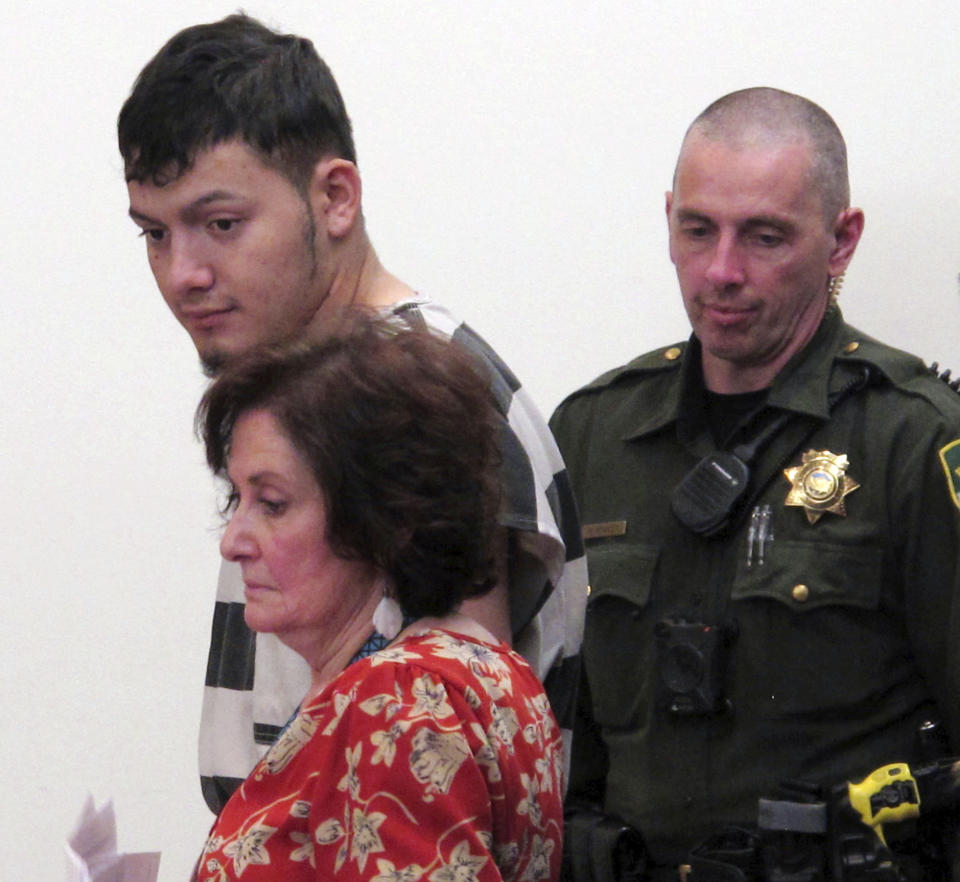 Wilber Ernesto Martinez-Guzman, 19, top left, of El Salvador, listens to proceedings during his initial appearance in Carson City Justice Court, Thursday, Jan. 24, 2019, in Carson City, Nev. Martinez-Guzman was arraigned on 36 felonies including two dozen weapon charges. He's a suspect in a series of four homicides earlier this month in Reno and south of Carson City in rural Gardnerville. Prosecutors say additional charges are pending. (AP Photo/Scott Sonner)