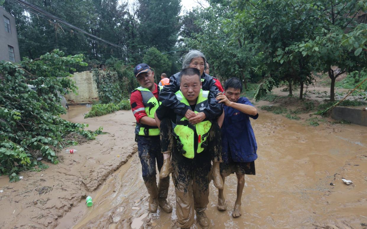 Rescue workers evacuate villagers stranded by floodwaters following heavy rainfall, in Donghenan village of Xingyang city, Henan province, China - REUTERS 