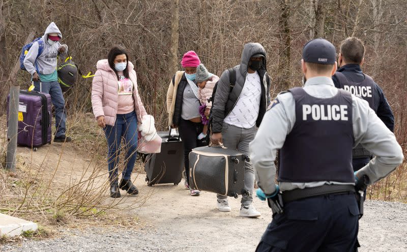 FILE PHOTO: Asylum seekers cross into Canada near a checkpoint on Roxham Road