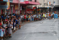 A crowd of people stand along the street during the arrival of Britain's Prince Harry and Meghan, Duchess of Sussex, in Suva, Fiji, October 23, 2018. REUTERS/Phil Noble