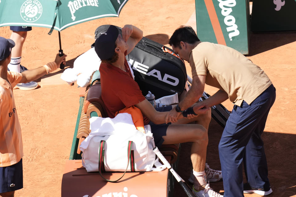 Italy's Jannik Sinner receives medical attention during his semifinal match of the French Open tennis tournament against Spain's Carlos Alcaraz at the Roland Garros stadium in Paris, Friday, June 7, 2024. (AP Photo/Christophe Ena)
