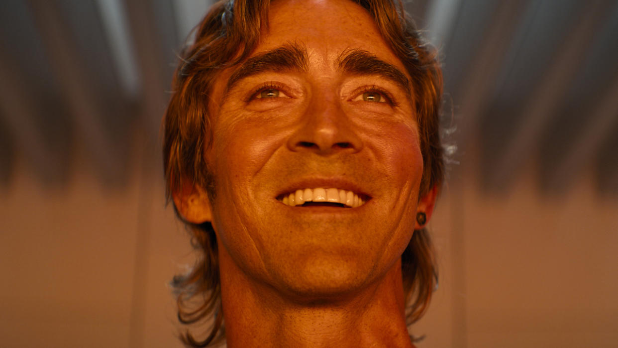  Lee Pace smiles while bathed in orange light in Foundation. 