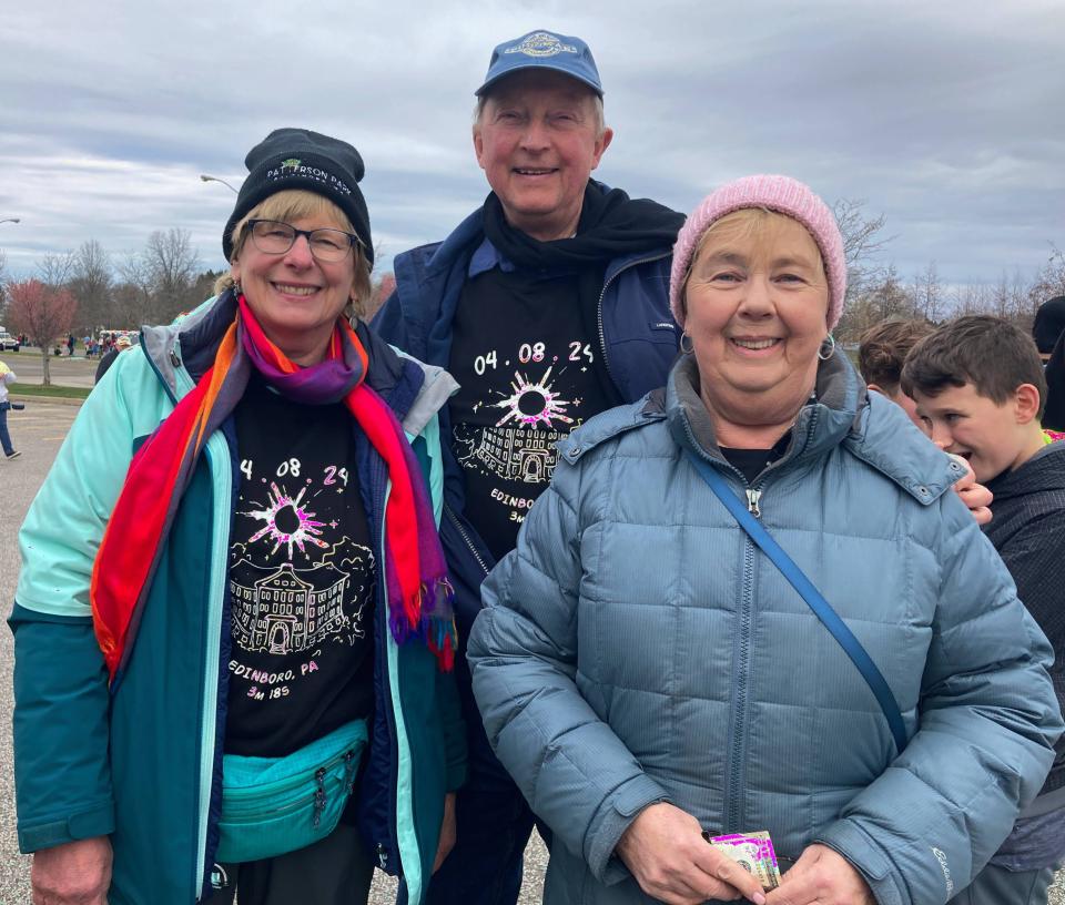 Friends Kathy Helzlsouer and Jean-Luc Renaux, of Baltimore, left, and Denise Joseph, of Pittsburgh, chose to watch the eclipse at PennWest Edinboro, cloudy or not.