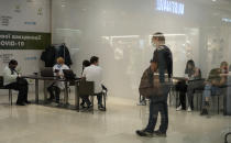 People wait for their turn in a vaccination center in a city mall in Kyiv, Ukraine, Thursday, Oct. 21, 2021. Coronavirus infections and deaths in Ukraine have surged to all-time highs amid a laggard pace of vaccination, which is one of the lowest in Europe. (AP Photo/Efrem Lukatsky)