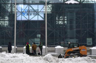 Men shovel snow in front of the Javits Center, which is being used as a COVID-19 vaccination site, in New York, Tuesday, Feb. 2, 2021. The site was closed today due to the inclement weather. Coronavirus vaccination sites across the Northeastern U.S. are getting back up and running after a two-day snowstorm that also shut down public transport, closed schools and canceled flights. Some vaccination sites in New York City remained closed, but others, including those run by the public hospital system, were open Tuesday. (AP Photo/Seth Wenig)