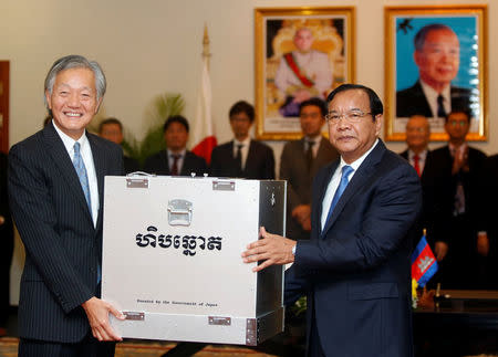 Japan's Ambassador to Cambodia Horinouchi Hidehisa (L) and Cambodia's Foreign Minister Prak Sokhonn hold a ballot box at the Ministry of Foreign Affairs and International Cooperation in Phnom Penh, Cambodia February 21, 2018. REUTERS/Samrang Pring