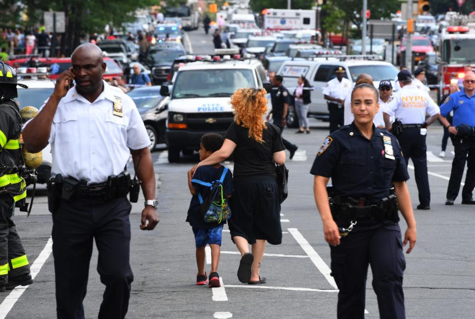 <p>A woman and a child walk past police outside the Bronx-Lebanon Hospital as they respond to an active shooter north of Manhattan in New York on June 30, 2017. (Timothy A. Clary/AFP/Getty Images) </p>