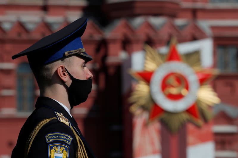 A Russian serviceman wearing a protective face mask stands before the Victory Day Parade in Red Square in Moscow